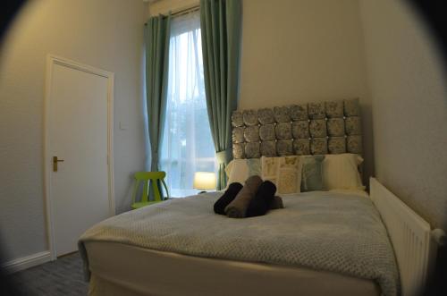 a bedroom with a large bed with a large window at Queens Guesthouse Manchester in Manchester