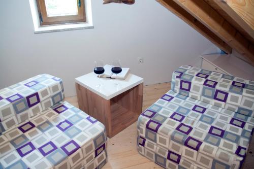 two chairs and a table with wine glasses on it at Villa Kudelik - Stone Story in Trogir