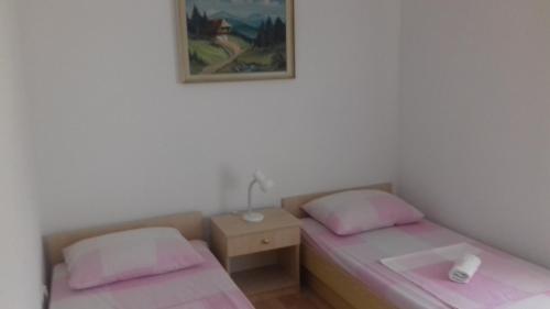 una camera con due letti e un comodino e una foto di Apartman Jezidžić a Kaštela (Castelli)