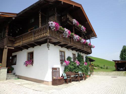 a building with a balcony with flowers on it at Landhaus Aigner in Mittersill