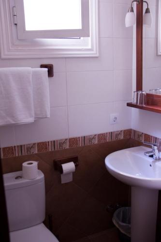 a bathroom with a toilet and a sink and a window at Hostal El Pilar in Madrid