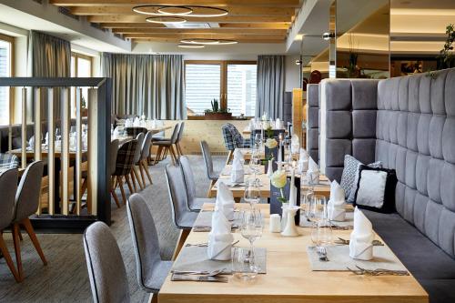 a dining room with long tables and chairs at Aktivhotel Alpendorf in Sankt Johann im Pongau