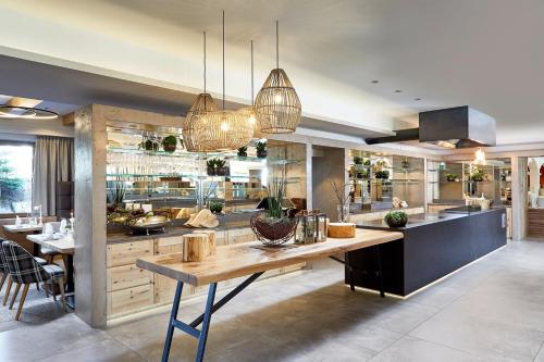 a large kitchen with a table and some lights at Aktivhotel Alpendorf in Sankt Johann im Pongau