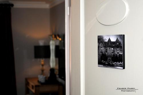 a picture of a building hanging on a wall at The Saracens Head Hotel - The Coaching Inn Group in Great Dunmow
