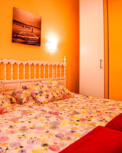 a bedroom with a bed with a floral bedspread at Playa De Arnadal Isla in Isla