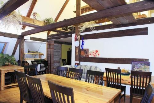 a dining room with a wooden table and chairs at Baltā māja in Pilsrundāle