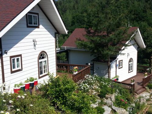 two white houses with flags in front of them at Sunny House in Pyeongchang 