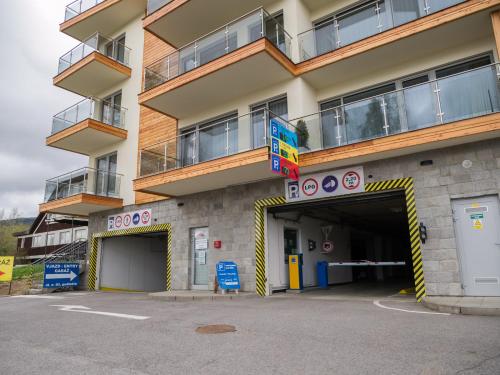 a building with a parking garage in front of it at Apartmán Cyril A 104 in Smokovce