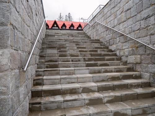 a set of stairs next to a stone wall at Apartmán Cyril A 104 in Smokovce