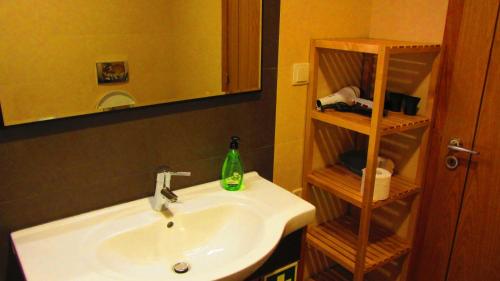 a bathroom with a sink and a mirror at Apartamentos Pátio da Aldeia in Armação de Pêra