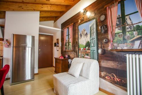 a living room with a refrigerator and a chair at Villa Gioiosa in Piantedo