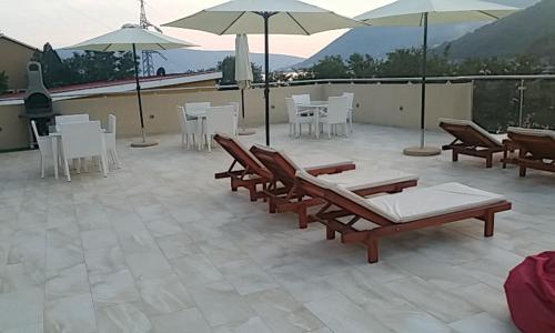 a patio with chairs and tables and umbrellas at Dream Vacation Apartments in Tivat