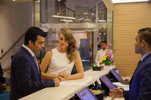 a man and a woman standing at a counter at Best Western Plus Pearl Creek in Dubai