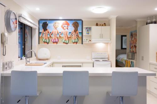 a kitchen with white counters and white cabinets at Beach House Getaway 2 in Smiths Beach