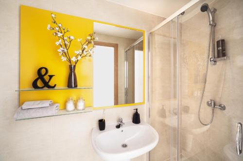 a bathroom with a sink and a shower with a mirror at Camplus Pamplona in Pamplona