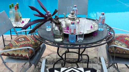 a glass table with bottles and a plant on it at Accra Royal Castle Apartments & Suites in Kwabenya