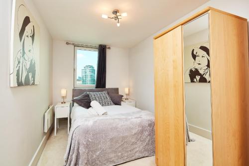 a bedroom with a bed and a mirror at Second Nest Thames View in London