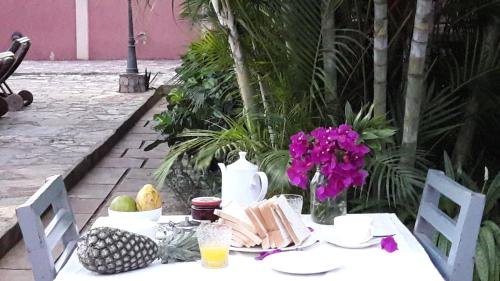 a white table with food and flowers on it at Accra Royal Castle Apartments & Suites in Kwabenya