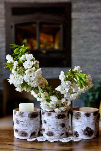 a vase with white flowers and a candle on a table at The Rockwell-Harrison Guest Lodge in Harrison Hot Springs