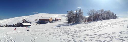 a ski lodge on a snow covered slope with people at Stone House Ilovemajella in Pretoro