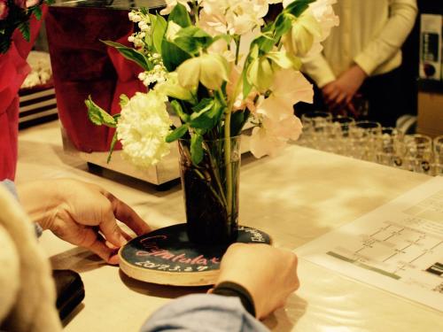 a person is arranging a vase of flowers on a table at Guest House On My Way in Sapporo