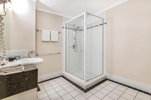 a bathroom with a shower and a sink at Regal Port Douglas in Port Douglas