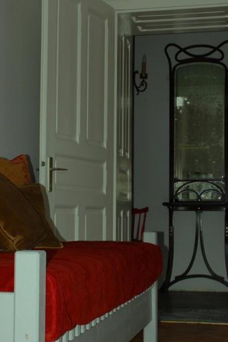 a bedroom with a bed with a red blanket and a mirror at Altstadthaus Cityappartements in Graz