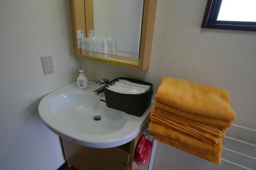 Un baño con lavabo, espejo y toallas. en Villa May Queen, en Fujikawaguchiko