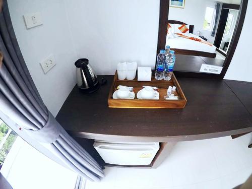 a table with a mirror in a room with a bed at Sunrise Inn in Krabi town