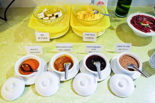 a table with cups and bowls of different types of food at Sea Star Resort in Phu Quoc