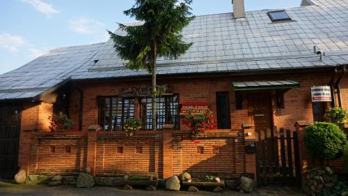 une maison en briques avec un palmier en face de celle-ci dans l'établissement Pas Birute, à Kaunas