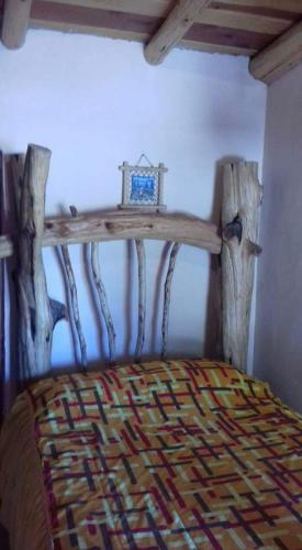 a bedroom with a bed with a wooden head board at Cabañas Margarito in Areponapuchi