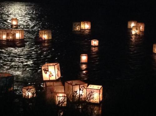 a group of candles floating in the water at night at Town Hotel 41 in Kanazawa