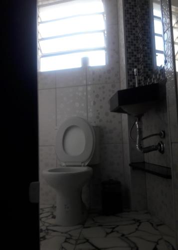 a bathroom with a toilet and a sink and a window at Hotel Flor da Vila Mariana in Sao Paulo