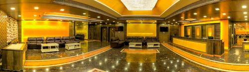 a large lobby with couches and tables in a building at Hotel Benzz Park Vellore in Vellore