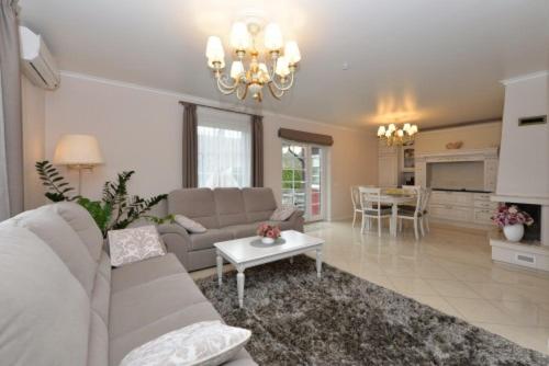 a living room with a couch and a table at Harmony Park Nida House in Nida