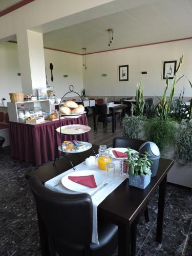 a dining room with a table with plates of food at Landhaus Eifelsicht in Hellenthal