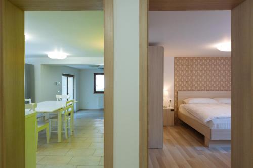 a bedroom with a bed and a kitchen with a table at Apartments Burja in Bled