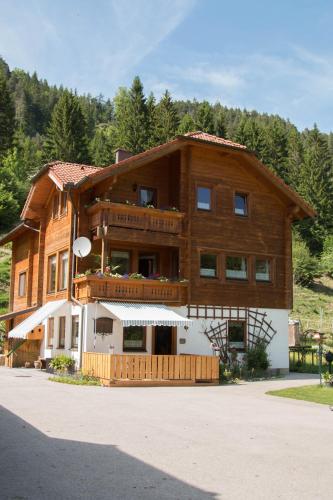 a large wooden building with a balcony on the side at Reiterbauernhof Maho in Sankt Aegyd am Neuwalde