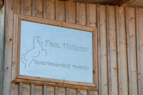 a sign in a frame on a wooden wall at Reiterbauernhof Maho in Sankt Aegyd am Neuwalde