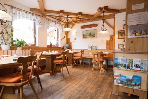 restauracja z drewnianymi podłogami, stołami i krzesłami w obiekcie Reiterbauernhof Maho w mieście Sankt Aegyd am Neuwalde