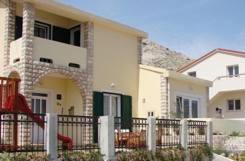 a house with a playground in front of it at Family apartments Grguric in Pag