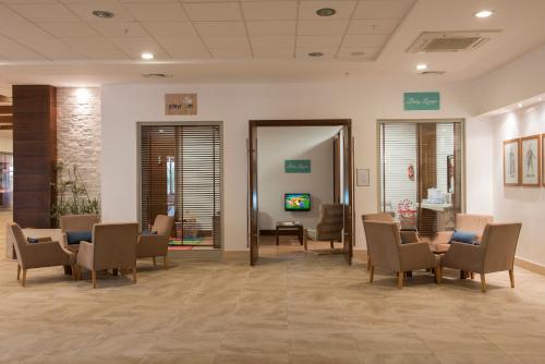 a waiting room in a hospital with chairs and tables at Barut B Suites in Side