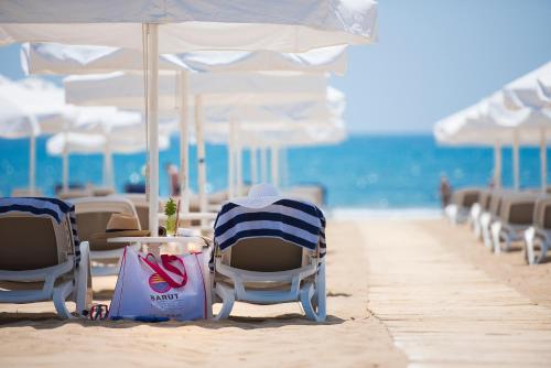 a row of chairs and umbrellas on a beach at Barut B Suites in Side