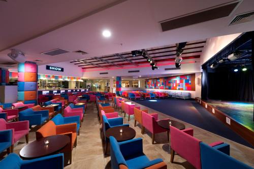 a bar with colorful chairs and a pool at Barut B Suites in Side