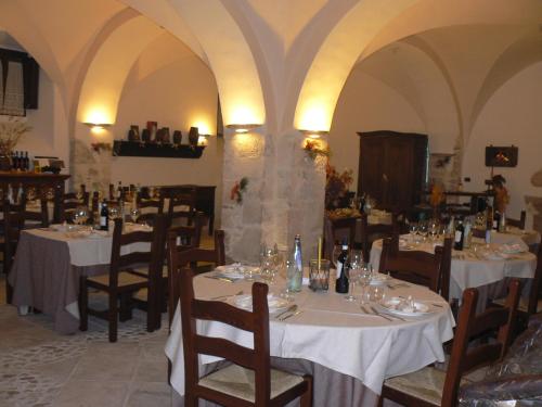 a dining room with tables and chairs with white table cloth at Residence Il Palazzo in Santo Stefano di Sessanio