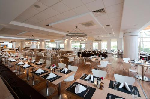 a banquet hall with tables and white chairs at Barut B Suites in Side