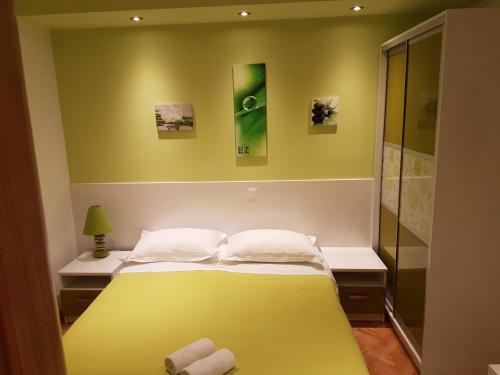 a bedroom with a yellow bed and a shower at House Villa Roza in Tučepi