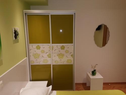 a room with a glass partition with flowers on the wall at House Villa Roza in Tučepi