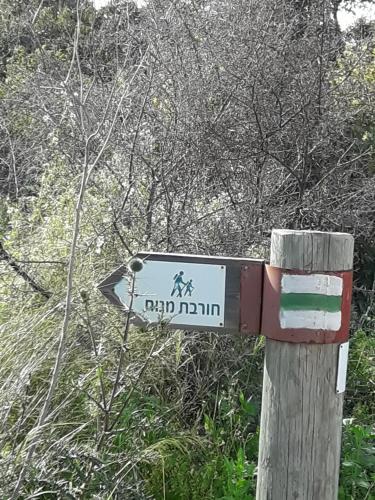 a sign on a wooden post on a trail at Country lodging in Manot in Manot